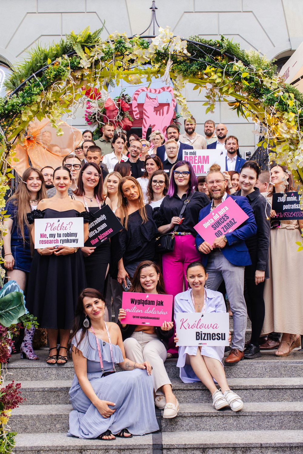 Uczestniczki WFS Ladies z hasłami o biznesie na schodach przed wydarzeniem